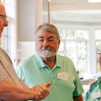 Mick Doxey and Beth Neumeier chatting with gentleman at event